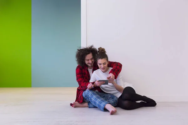 Young Couple using digital tablet on the floor — Stock Photo, Image