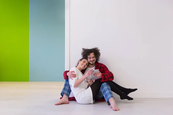 Casal jovem usando tablet digital no chão — Fotografia de Stock