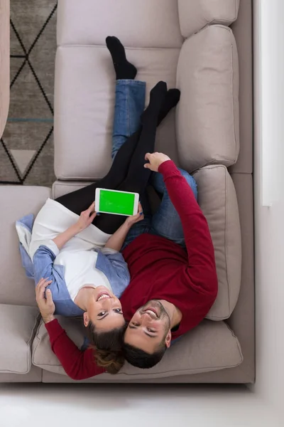 Par koppla av hemma med tablet-datorer — Stockfoto