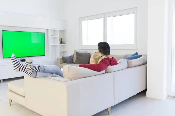 Pareja joven en el sofá viendo la televisión — Foto de Stock