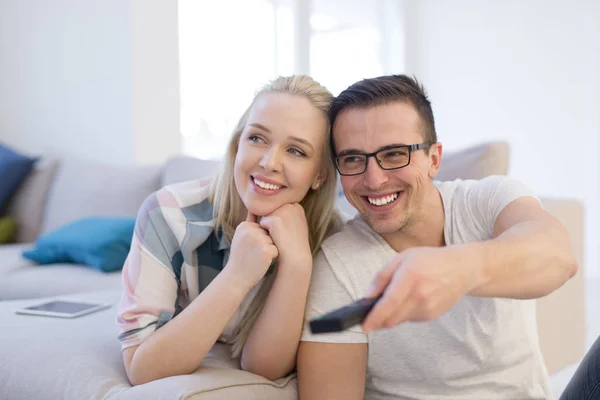 Jeune couple sur le canapé regarder la télévision — Photo