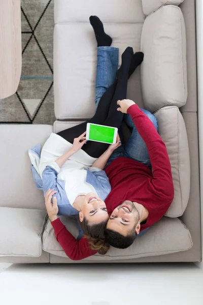 Pareja relajante en casa con tabletas — Foto de Stock