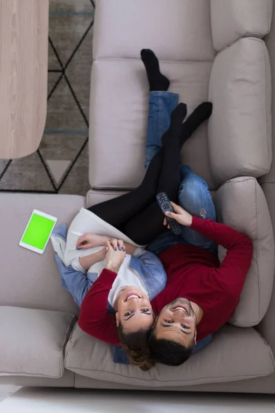 Pareja joven en el sofá viendo la televisión vista superior — Foto de Stock