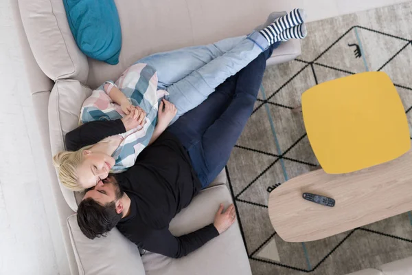 Молодая пара на диване смотрит телевизор вид сверху — стоковое фото
