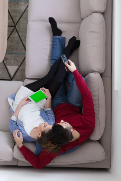 Jong (echt) paar op de bank kijken naar televisie bovenaanzicht — Stockfoto