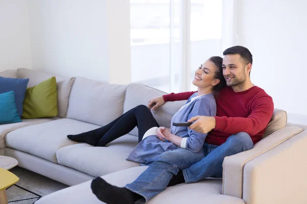 Jeune couple sur le canapé regarder la télévision — Photo