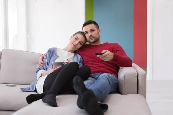 Mladý pár na pohovce u televize — Stock fotografie