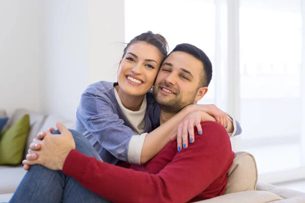 Casal abraçando e relaxando no sofá — Fotografia de Stock