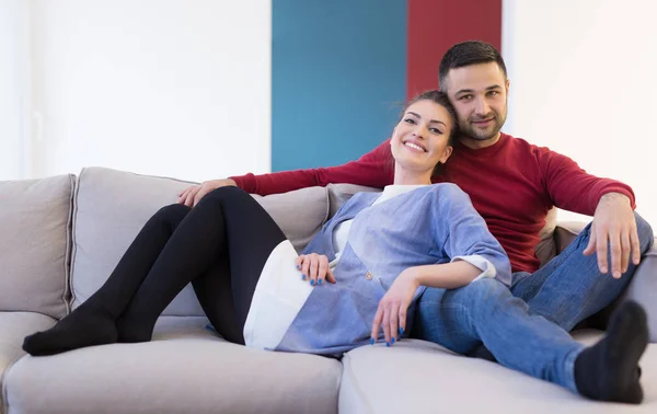 Пара обіймає і розслабляється на дивані — стокове фото