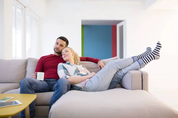 Пара обіймає і розслабляється на дивані — стокове фото
