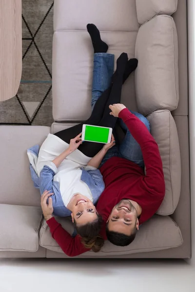 Pár v pohodlí domova u počítačů typu tablet — Stock fotografie
