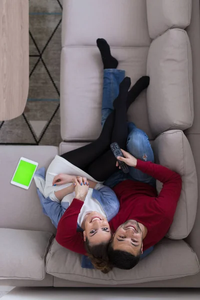 Νεαρό ζευγάρι στον καναπέ βλέποντας τηλεόραση κάτοψη — Φωτογραφία Αρχείου