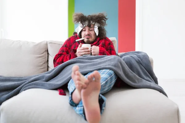 Hombre joven con gripe y fiebre — Foto de Stock