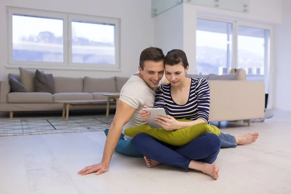 Νεαρό ζευγάρι χρησιμοποιώντας ψηφιακό tablet στο πάτωμα — Φωτογραφία Αρχείου