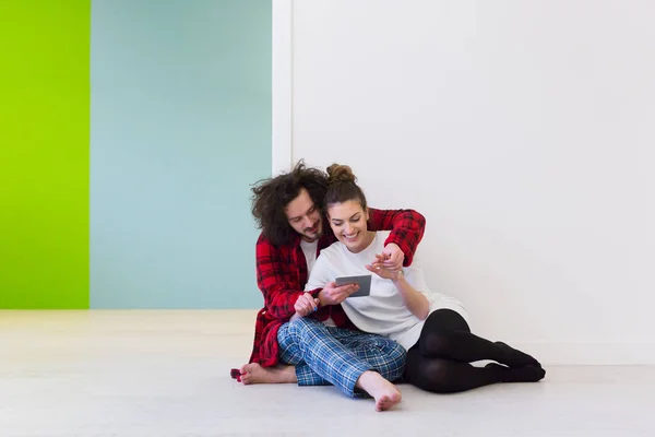 Casal jovem usando tablet digital no chão — Fotografia de Stock