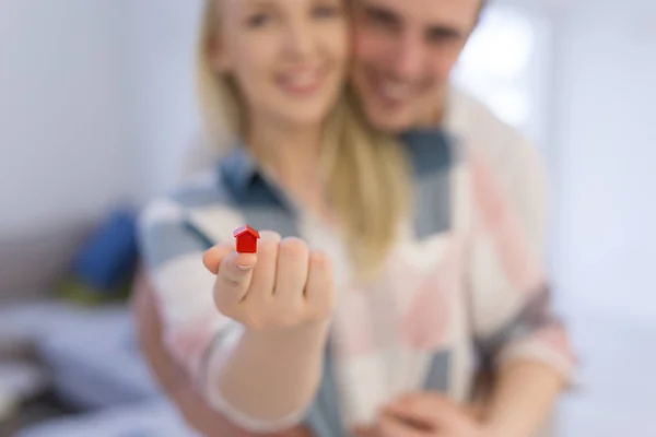 Casal mostrando pequena casa vermelha nas mãos — Fotografia de Stock