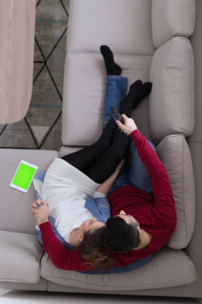 Young couple on the sofa watching television top view — Stock Photo, Image