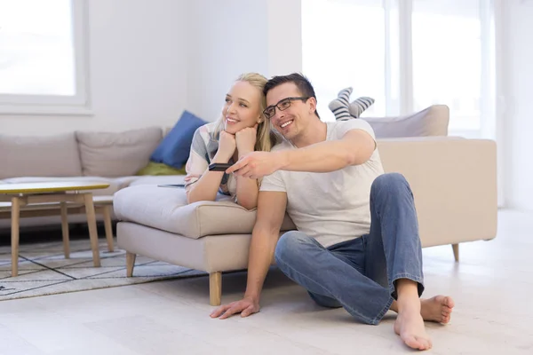 Pareja joven en el sofá viendo la televisión — Foto de Stock