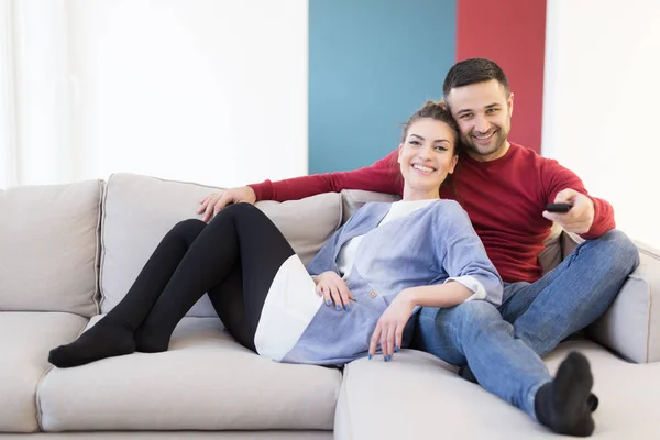 Mladý pár na pohovce u televize — Stock fotografie