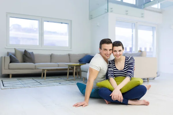 这对可爱的夫妇在家里客厅的地板上自由自在地坐着 — 图库照片