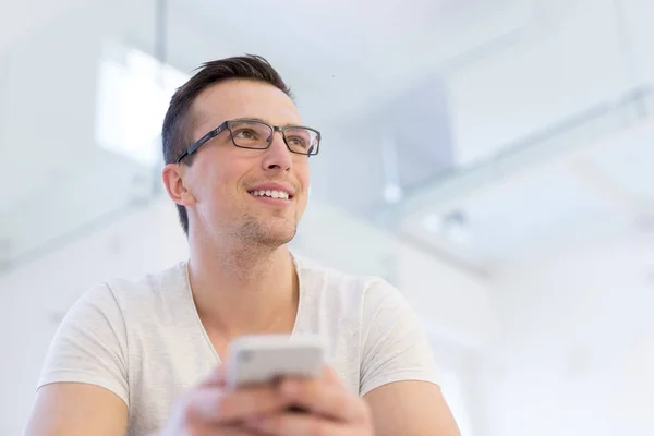 Junger Mann mit Handy zu Hause — Stockfoto