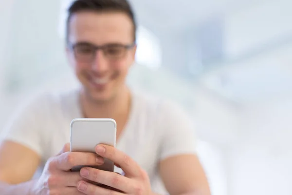 Joven usando un teléfono móvil en casa —  Fotos de Stock