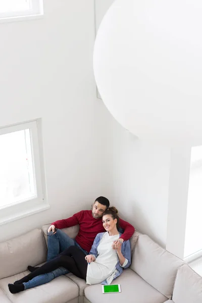 Giovane coppia sul divano a guardare la televisione — Foto Stock
