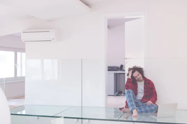 Jovem freelancer em roupão de banho trabalhando em casa — Fotografia de Stock