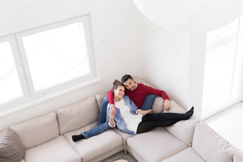 couple relaxing at  home with tablet computers