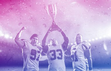 Amerikan futbolu takımı cu zaferini kutluyor kupa ile