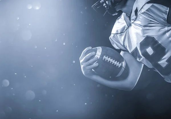 Jogador de futebol americano segurando bola enquanto corre em campo — Fotografia de Stock