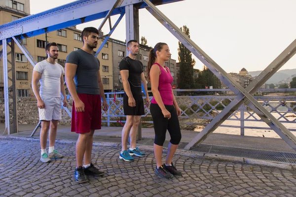 Bir grup genç insan köprüden koşu — Stok fotoğraf