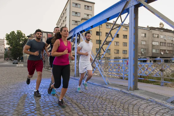 Bir grup genç insan köprüden koşu — Stok fotoğraf