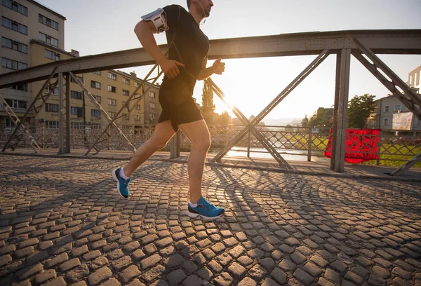 Mann joggt an sonnigem Morgen über Brücke — Stockfoto
