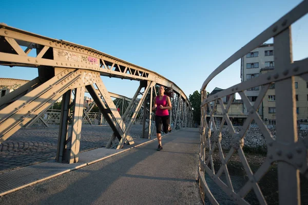 Köprüden güneşli sabah koşu kadın