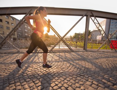 Köprüden güneşli sabah koşu kadın