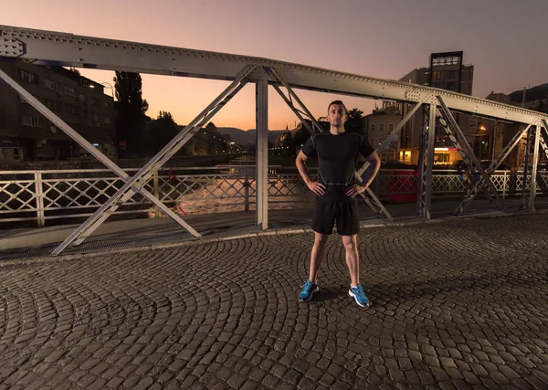 Muž běhat přes most ve městě — Stock fotografie