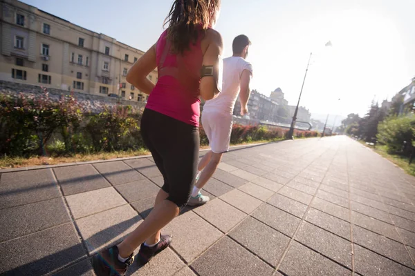 Jeune couple jogging dans la ville — Photo