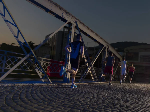 Ungdomar som jogging över bron — Stockfoto
