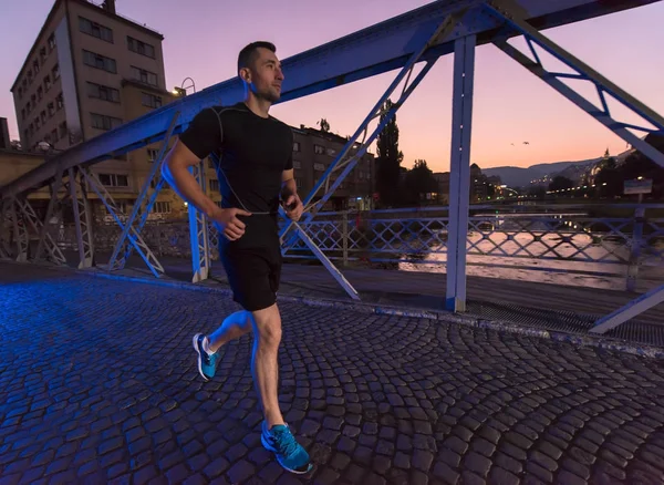 Mann joggt in der Stadt über Brücke — Stockfoto