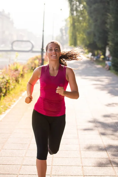 Kobieta, jogging w słoneczny poranek — Zdjęcie stockowe