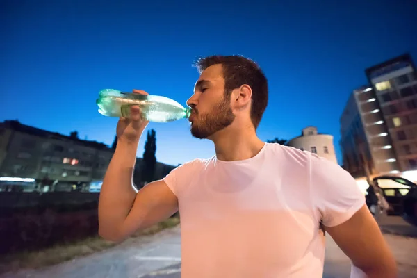 Mann trinkt Wasser nach Laufeinheit — Stockfoto