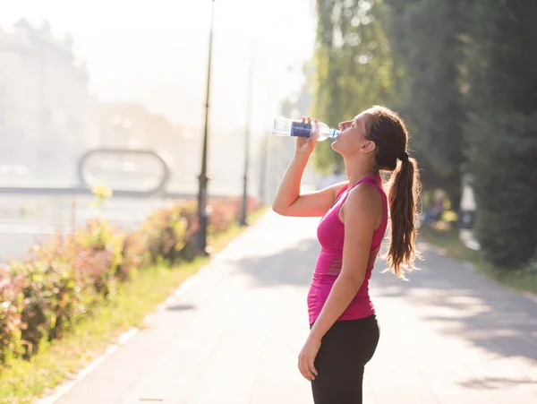Frau trinkt nach Joggen Wasser aus Flasche — Stockfoto