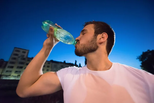 Mann trinkt Wasser nach Laufeinheit — Stockfoto