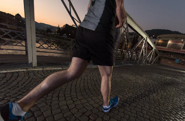 Homme jogging à travers le pont dans la ville — Photo