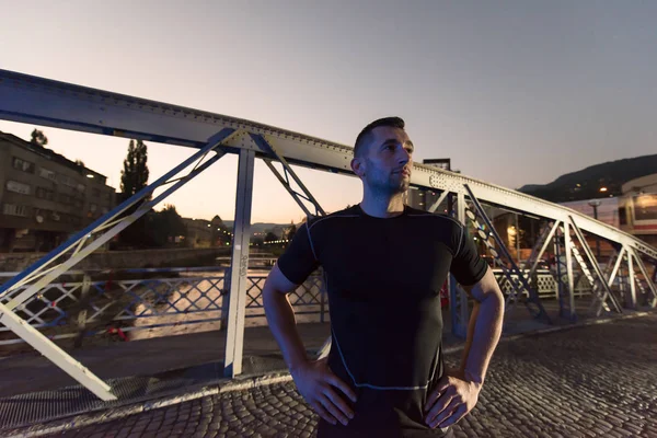 Homme jogging à travers le pont dans la ville — Photo