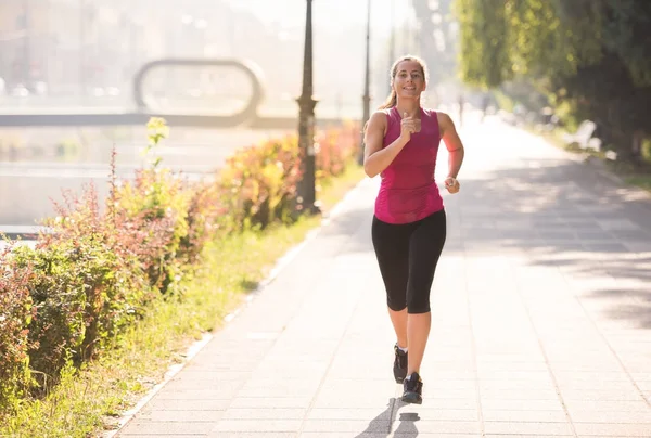 Kobieta, jogging w słoneczny poranek — Zdjęcie stockowe