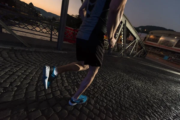 Muž běhat přes most ve městě — Stock fotografie