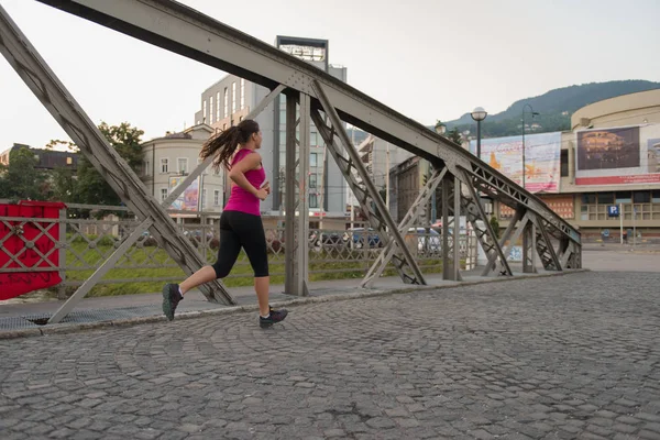 Mujer corriendo a través del puente en la mañana soleada —  Fotos de Stock