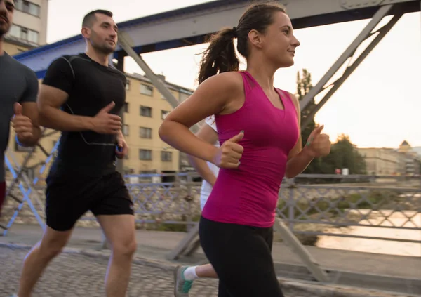 Groep jongeren joggen over de brug — Stockfoto